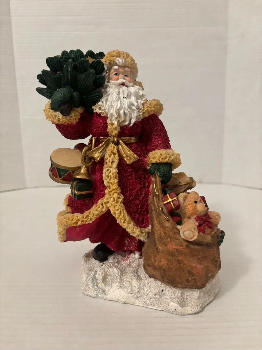 Festive Red Santa Figurine with Green Tree and Brown Toy Sack